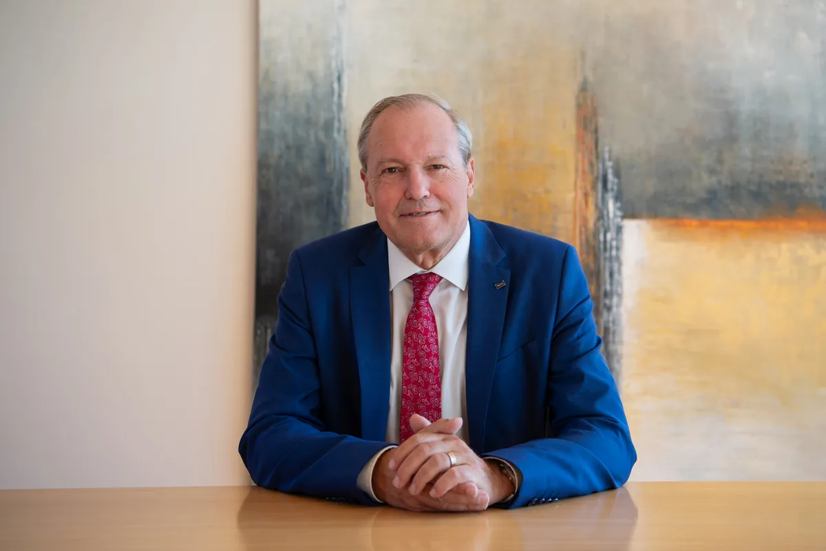 Porträtfoto eines Mannes an einem Tisch.